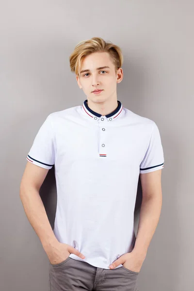 灰色スタジオの壁の近くのポケットに手と立っている白いシャツでハンサムな男の子ティーンエイ ジャー — ストック写真