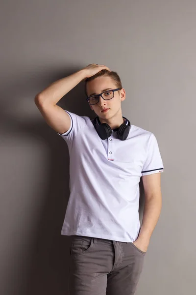 Όμορφο Αγόρι Έφηβος Ακουστικά Στέκεται Κοντά Τοίχο Γκρι Στούντιο — Φωτογραφία Αρχείου
