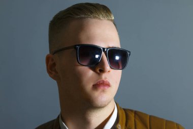 Yakışıklı deri ceketli ve güneş gözlüğü gri Studio, kapat