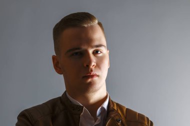 Yakışıklı delikanlı deri ceket teşkil gri Studio, yakın çekim