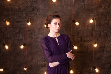 Studio tuğla duvar ve lambalar ile genç ve güzel esmer standları