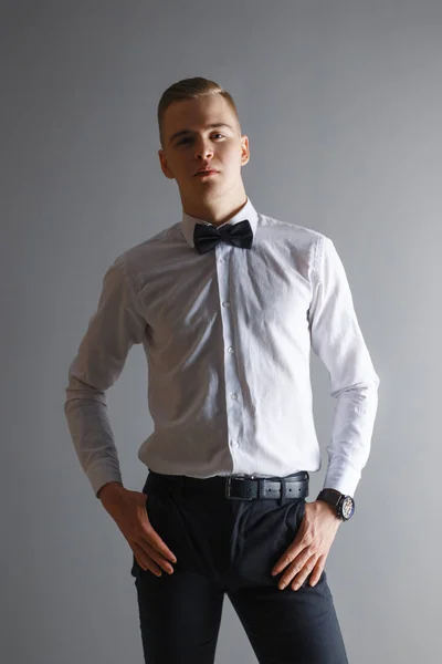 Beau Homme Chemise Blanche Nœud Papillon Pose Studio Gris — Photo