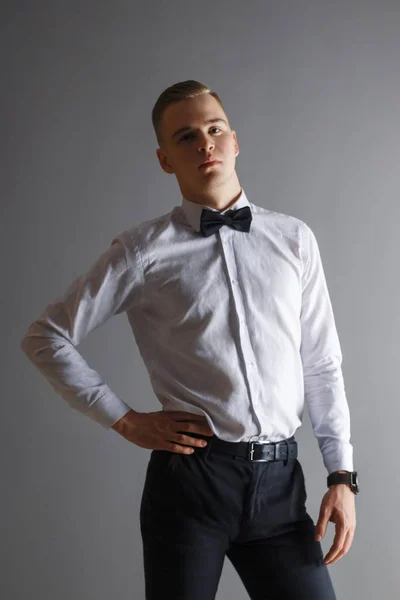 Handsome Young Man White Shirt Bow Tie Poses Grey Studio — Stock Photo, Image