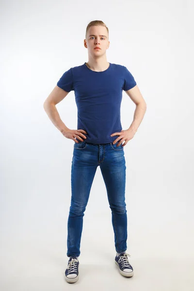 穿着蓝色衬衫和牛仔裤的年轻英俊男子在白色演播室 全身的姿势 — 图库照片