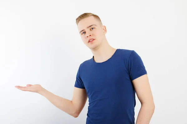 Jovem Bonito Homem Camisa Azul Mostra Algo Estúdio Branco — Fotografia de Stock