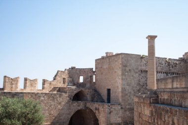 Lindos Acropolis, Rodos, Yunanistan, mavi gökyüzü, zeytin ağacı ve güzel deniz manzaralı arka planda Hellenistik stoa sütunlarda