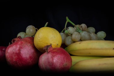 Nar ve diğer meyveler siyah bir zemin üzerine