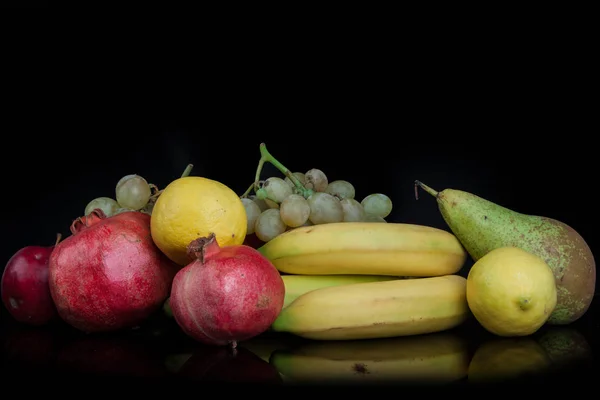 石榴和其他水果在黑色背景下 — 图库照片