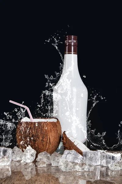 tropical coconut with ice and splashing water on black background