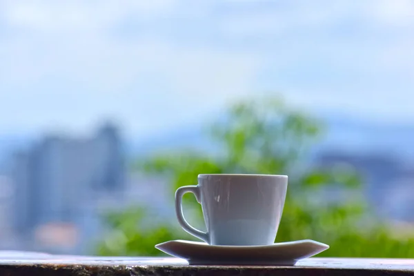 Sip coffee and gaze out at the city, with tall buildings and beautiful skies.