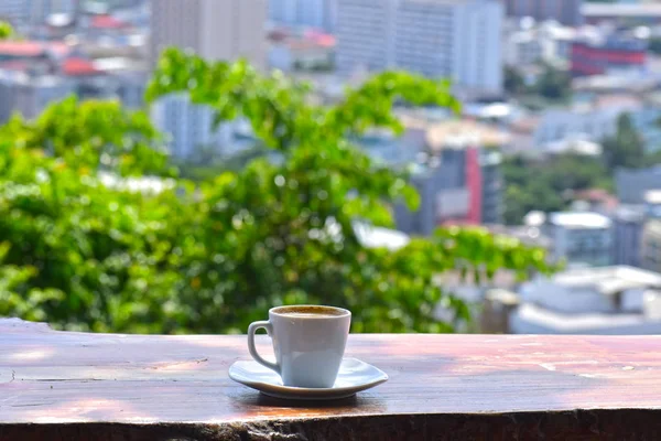 Sip coffee and gaze out at the city, with tall buildings and beautiful skies.