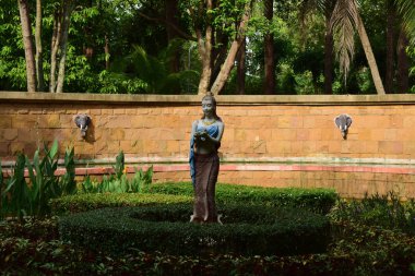 Parktaki heykeller Ağaçlarla çevrili güzel ve tatlı bir kadın heykeli