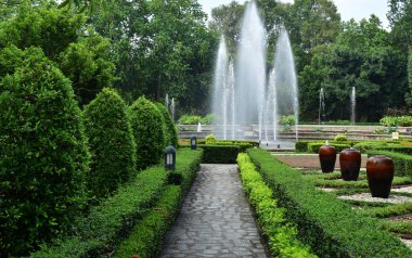 Bahçedeki çeşme ve güzel yeşil ağaçlarla çevrili taze atmosfer.