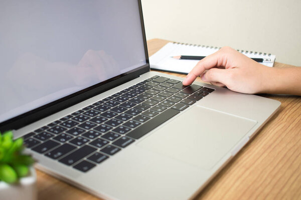 Woman's hands are typing the computer keyboard on the desk.