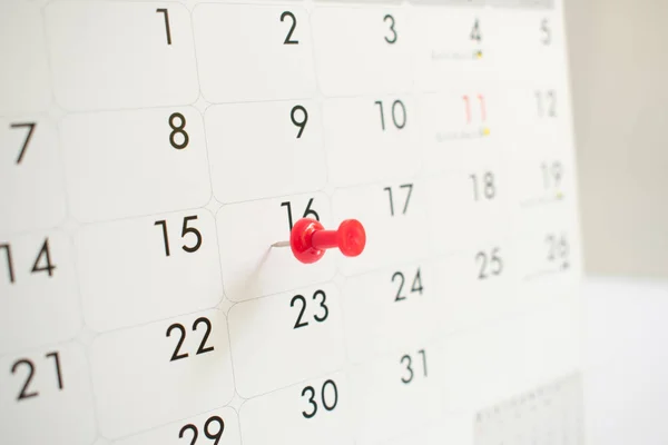A red pin on the event calendar.background, close up, time