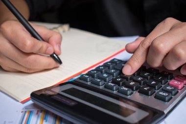 Asyalı, siyah gömlek giyen bir adam, rekor bir numara. Hesap makinesinden türetilmiştir.