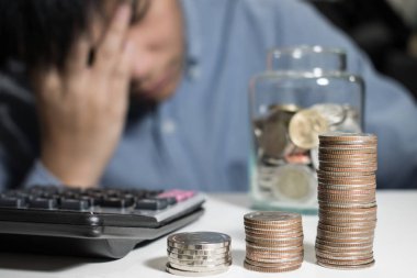 Asya adam içinde mavi gömlek vardır vurguladı hakkında para içinde the Oda.