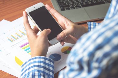 İşadamı telefon yoluyla metin mesajları gönderiyor. Üst görünüm