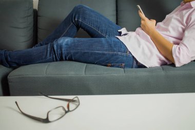 İnsanlar odadaki kanepede telefon oynuyorlar..