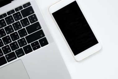 Modern beyaz tarzda bir masada akıllı telefon görüntüsü. Siyah ekran.