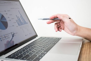 İşadamının görüntüsü lapto üzerindeki grafiği analiz ediyor.