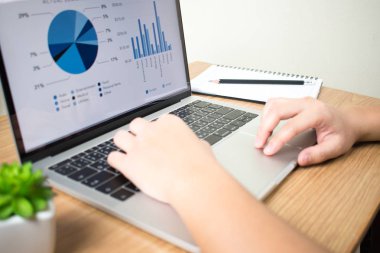 Masabaşında dizüstü bilgisayarlarda finansal grafiklerle çalışan işadamları