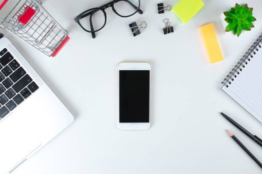 Üst görünüm, modern beyaz masada siyah ekran akıllı telefon. Online 
