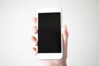 Akıllı telefonları beyaz arka planda tutan genç eller, üst görünüm
