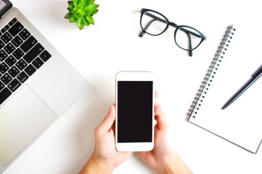 Üst görünüm modern bir çalışma üzerinde siyah ekran smartphone tutar