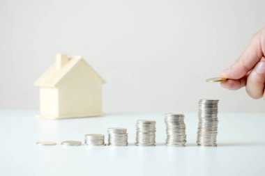 Tabl üzerinde sikke yığını üzerinde bir sikke tutan ele yakın