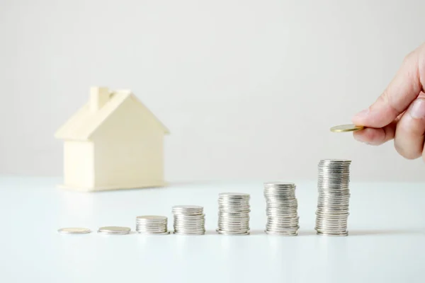 Close to the hand holding a coin above the coin pile on the tabl — Stock Photo, Image