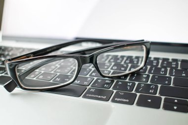 Dizüstü bilgisayarlarda işadamlarının gözlüklerine yakın çekim.