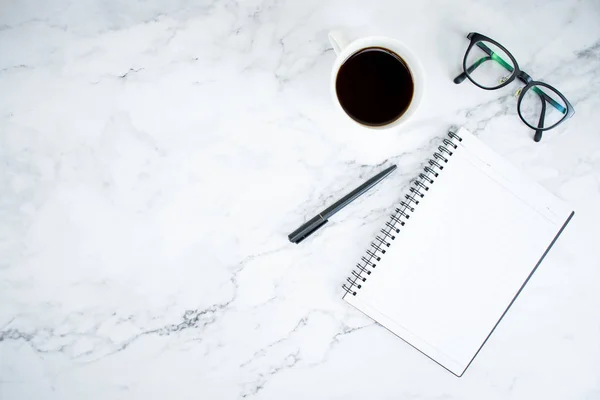 Mesa de mármore com caderno, copos e café na vista superior — Fotografia de Stock