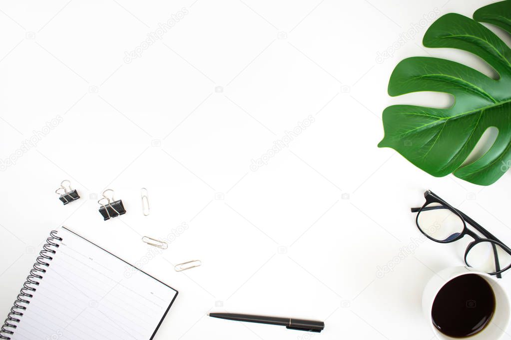 Top view image on a white table workspace with laptop, palm leaf