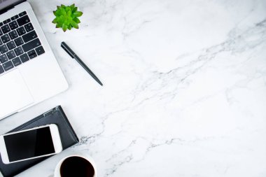 Dizüstü bilgisayar, kahve ve aksesuarları ile mermer çalışma masası. Üst görünüm w