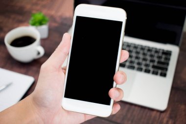 Elinizi kapatın akıllı telefonu masanın üzerinde tutuyor.