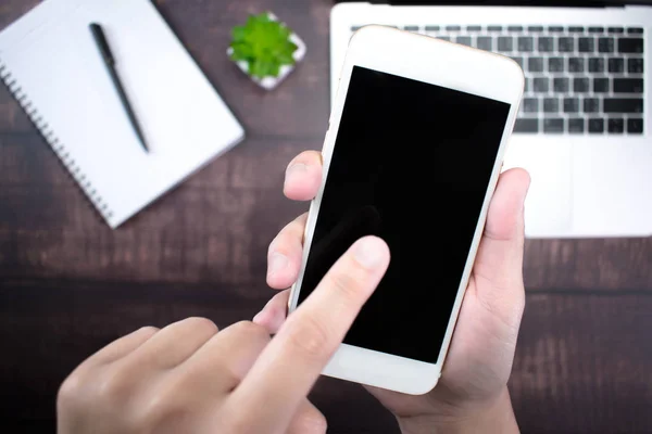 Cerca de la mano, utilizando un teléfono inteligente en un escritorio moderno. Utilice technolo — Foto de Stock