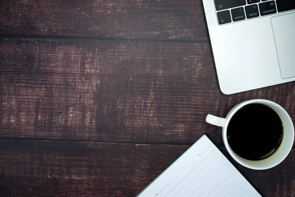 Un espacio de trabajo con cuadernos vacíos, café y computadoras portátiles para jóvenes —  Fotos de Stock