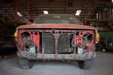 Bir oto tamir servisinde eski araba enkazı.