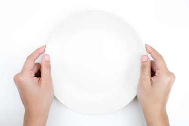 El beyaz siyah zeminde boş bir tabak tutuyor..