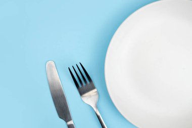 Tabağın üst görüntüsü ve mavi arka planda kaşık. 