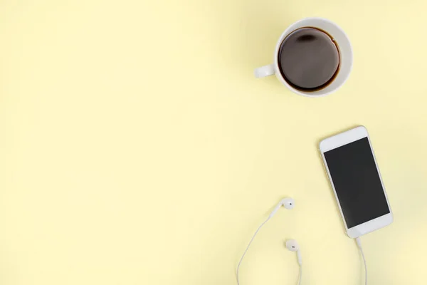 Üst Manzara. Kahve ve akıllı telefon. Kulaklığı sarı arka planda. — Stok fotoğraf