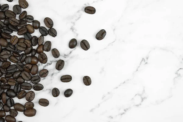 Закрыть коричневые кофейные бобы на мраморном фоне с — стоковое фото