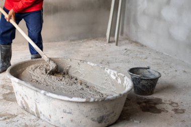 İnşaat işçileri büyük tanklara çimento karıştırıyor