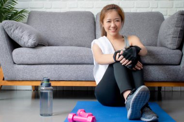 Asyalı kadınlar evde egzersiz yaptıktan sonra mutlu bir şekilde gülümsüyorlar. Evden antrenman.