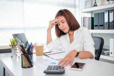 Asyalı kadınlar ofis masasında çok çalıştıktan sonra stresli hissederler. Aşırı çalışma ve uykusuzluk kavramı.