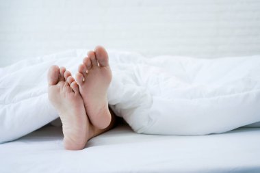 Asyalı ayağının odadaki bir yatakta uyumasına yakın çekim. Sağlıklı rahatlama kavramı.