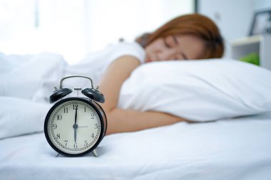 Yatağın başucundaki siyah çalar saati kapat. Ve genç bayan arka plan için yumuşak bir yastıkta uyuyor..