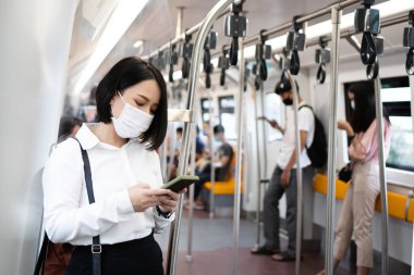 Ülkede COVID 19 salgını varken metroyla seyahat eden Asyalı bir kadın..