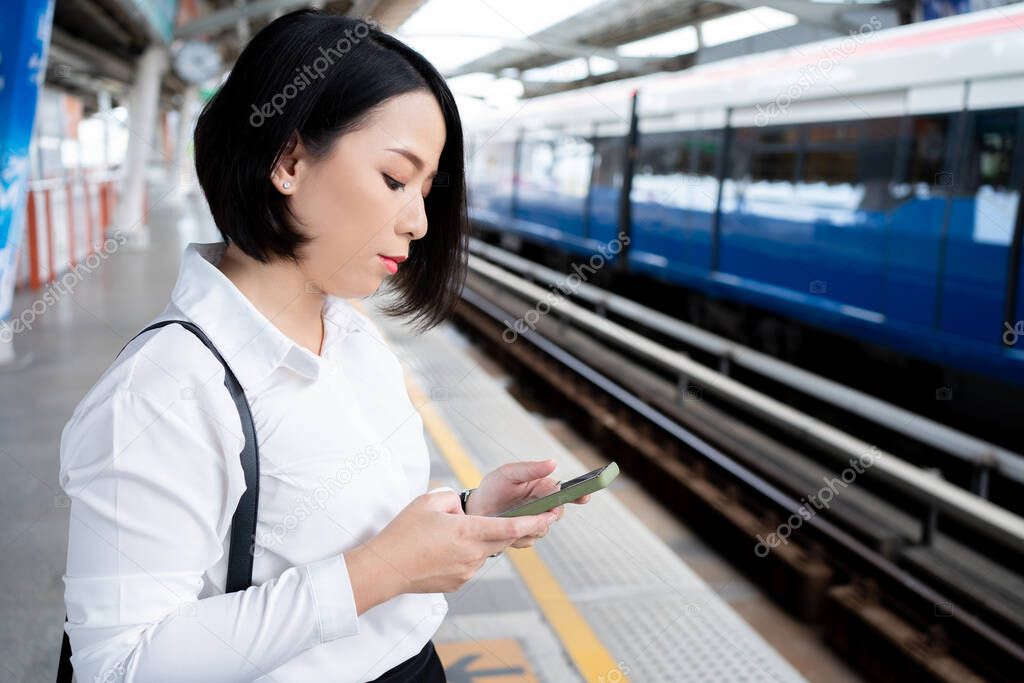 A young Asian businessman waits for the subway every morning